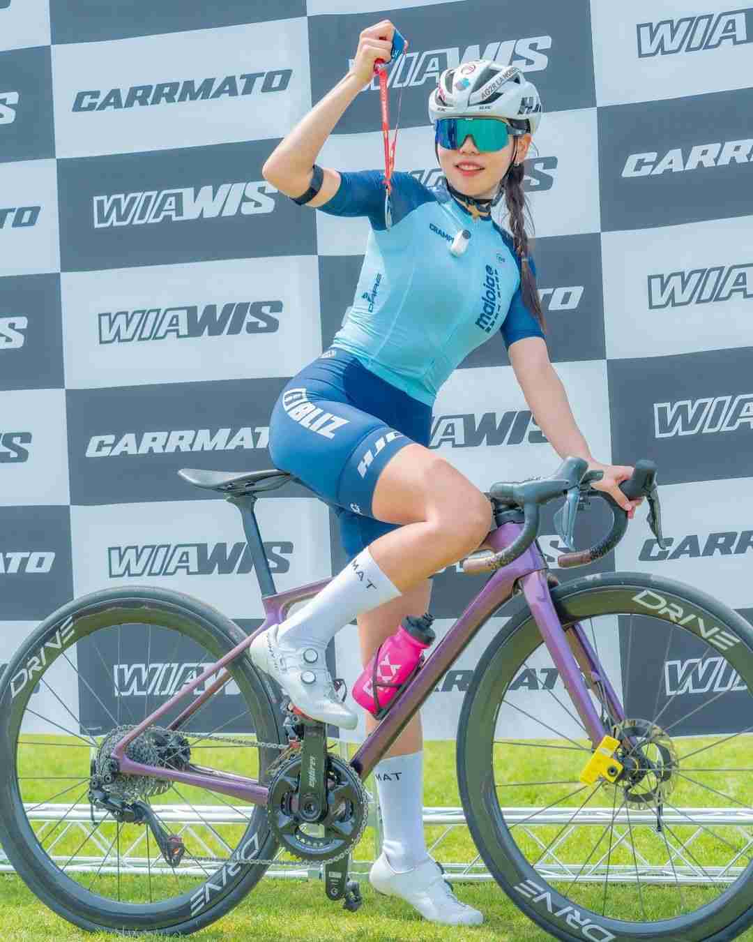 A Korean Female Cyclist Celebrates Victory at the Finish Line of A WIAWIS Sponsored Event